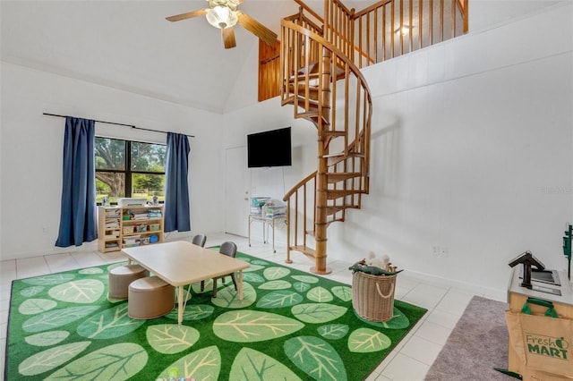 living room with stairs, tile patterned flooring, ceiling fan, and high vaulted ceiling
