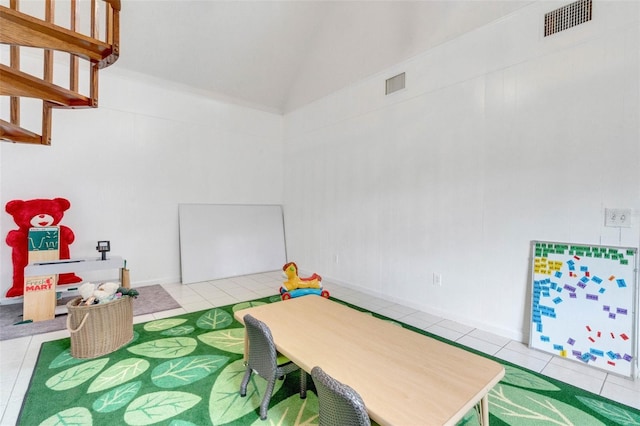 recreation room featuring tile patterned flooring, visible vents, and vaulted ceiling
