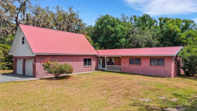 view of front of house with metal roof, brick siding, and a front yard