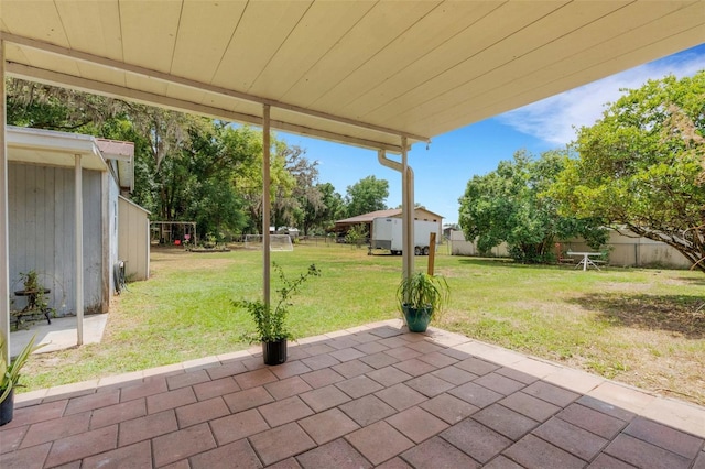 view of patio with an outbuilding, a storage shed, and a fenced backyard