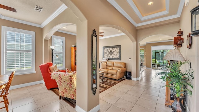 hallway featuring arched walkways, light tile patterned flooring, ornamental molding, baseboards, and recessed lighting