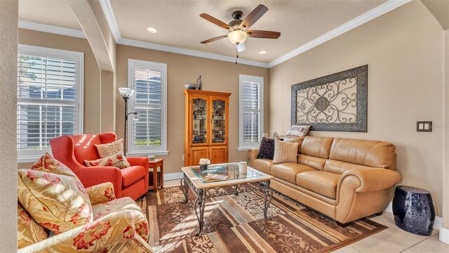 living area featuring a ceiling fan, ornamental molding, baseboards, a textured ceiling, and recessed lighting
