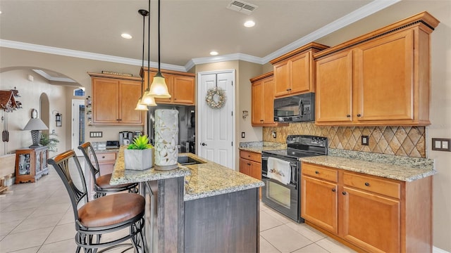 kitchen with black appliances, light tile patterned floors, arched walkways, light stone countertops, and a breakfast bar