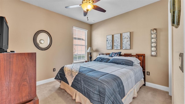 bedroom featuring light carpet, baseboards, and a ceiling fan