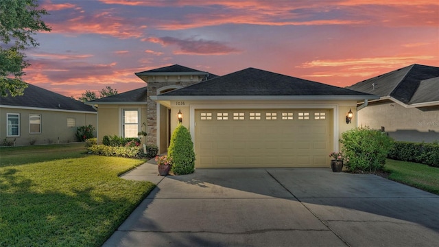 single story home with concrete driveway, stucco siding, an attached garage, a front yard, and stone siding