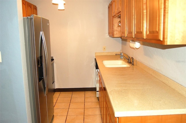 255 S Pennsylvania Ave, Lake Alfred, FL 33850 - kitchen with stainless steel refrigerator with ice dispenser, a sink, light countertops, brown cabinets, and light tile patterned floors