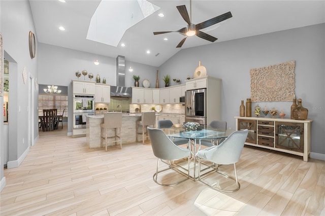 7313 Crape Myrtle Way, Sarasota, FL 34241 - dining room featuring high vaulted ceiling, light wood-type flooring, ceiling fan, recessed lighting, and a skylight