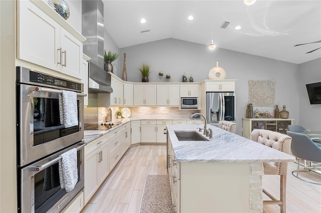 7313 Crape Myrtle Way, Sarasota, FL 34241 - kitchen with a sink, stainless steel appliances, a breakfast bar, an island with sink, and backsplash