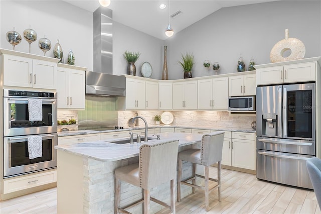 7313 Crape Myrtle Way, Sarasota, FL 34241 - kitchen with appliances with stainless steel finishes, vaulted ceiling, wall chimney exhaust hood, a sink, and light stone counters
