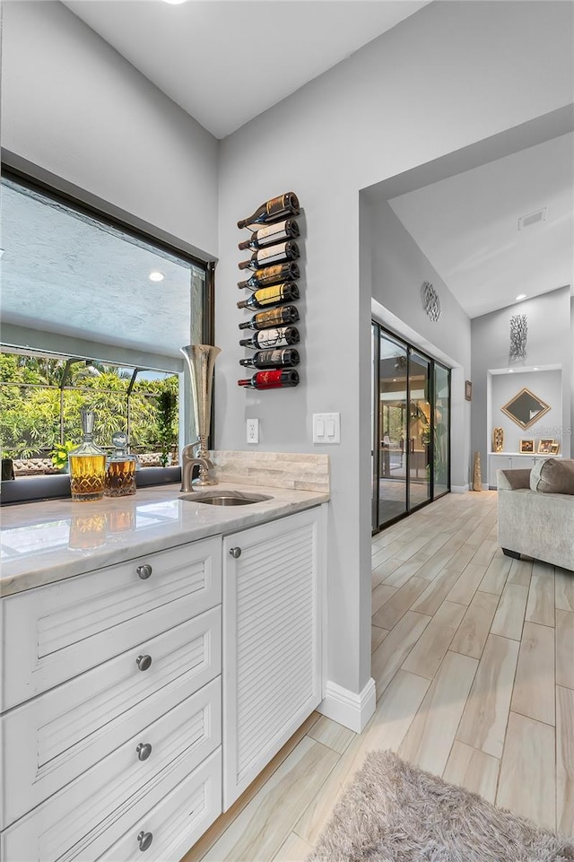 7313 Crape Myrtle Way, Sarasota, FL 34241 - indoor bar with plenty of natural light, light wood-style flooring, and baseboards