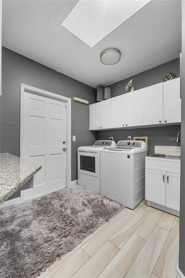 7313 Crape Myrtle Way, Sarasota, FL 34241 - laundry room with washer and clothes dryer, cabinet space, and a skylight