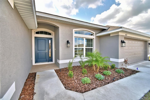 property entrance featuring stucco siding and a garage