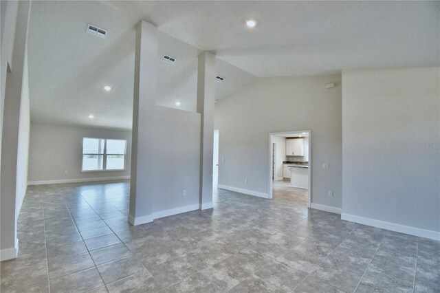 unfurnished room with baseboards, recessed lighting, high vaulted ceiling, and light tile patterned floors