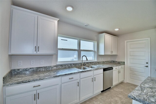kitchen featuring a sink, stainless steel dishwasher, white cabinets, light tile patterned floors, and recessed lighting