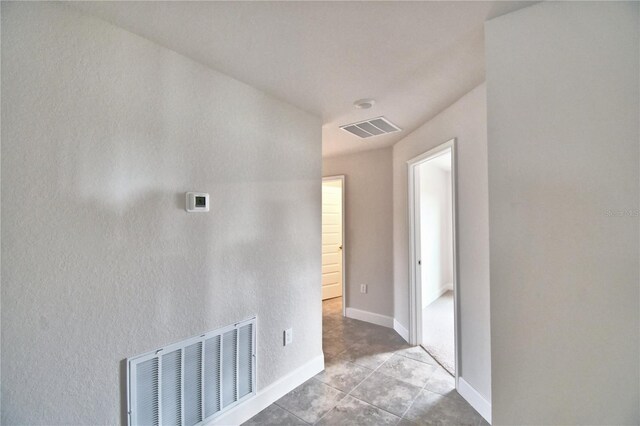 unfurnished room featuring tile patterned floors and baseboards