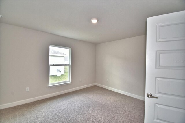 carpeted spare room with baseboards