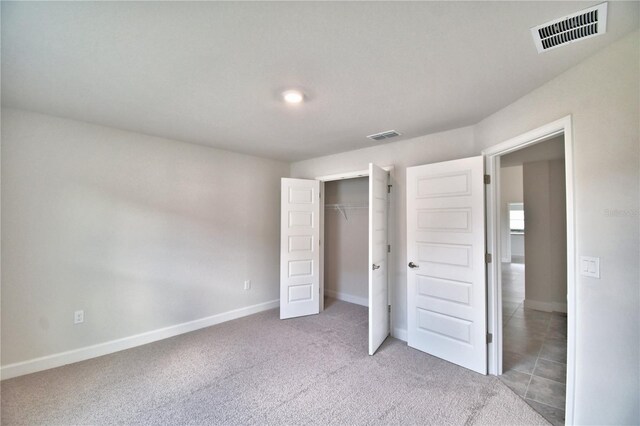 unfurnished bedroom featuring carpet floors, baseboards, and a closet
