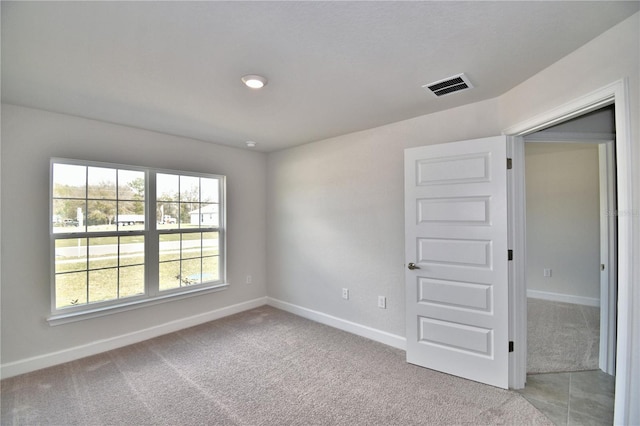 unfurnished room featuring baseboards and light colored carpet