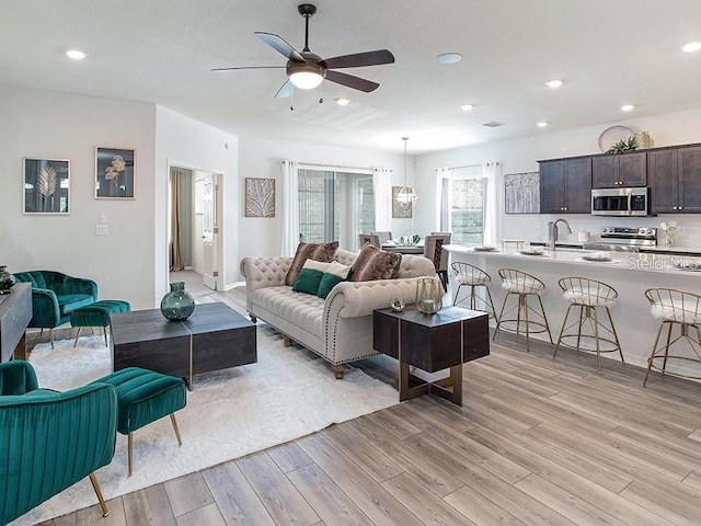 living room featuring ceiling fan, recessed lighting, and light wood-style floors