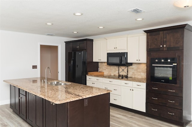 4008 S Carlisle Rd, Lakeland, FL 33813 - kitchen with black appliances, light wood-style floors, a kitchen island with sink, backsplash, and crown molding