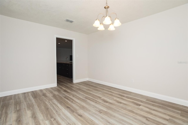 4008 S Carlisle Rd, Lakeland, FL 33813 - unfurnished room with light wood-style flooring and a chandelier