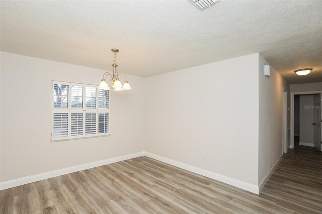 4008 S Carlisle Rd, Lakeland, FL 33813 - empty room featuring light wood-style flooring, a textured ceiling, and a chandelier