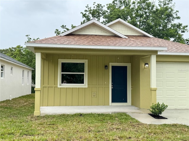 625 W 9th St, Lakeland, FL 33805 - view of front of property with roof with shingles, a garage, board and batten siding, and a front lawn