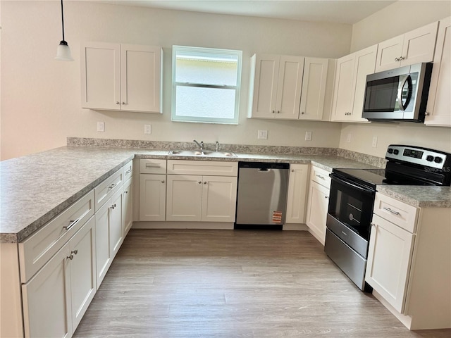 625 W 9th St, Lakeland, FL 33805 - kitchen featuring appliances with stainless steel finishes, a sink, a peninsula, and light countertops
