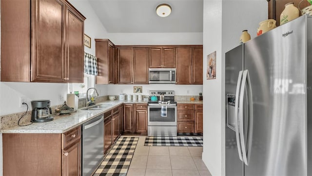 242 Kings Pond Ave SW, Winter Haven, FL 33880 - kitchen featuring stainless steel appliances, a sink, light tile patterned flooring, and light stone countertops