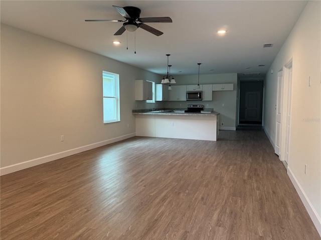 629 W 9th, Lakeland, FL 33805 - kitchen with open floor plan, stainless steel microwave, baseboards, a peninsula, and recessed lighting