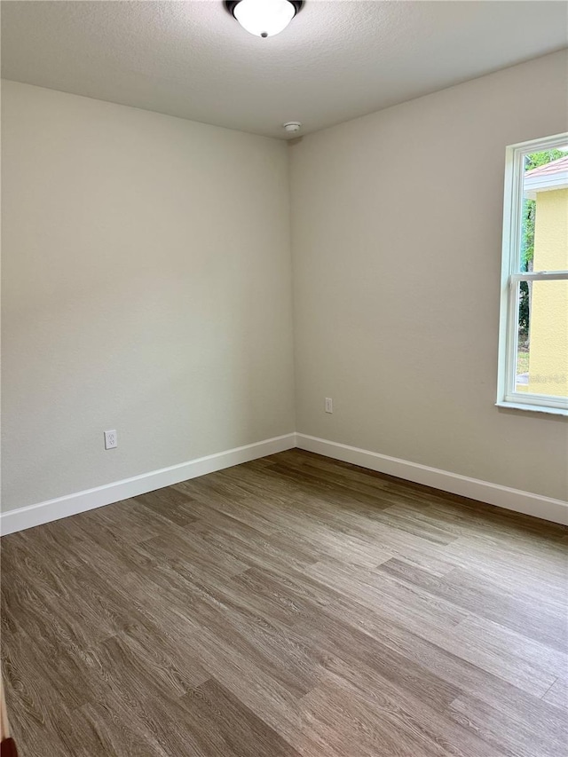 629 W 9th, Lakeland, FL 33805 - empty room with dark wood-style floors, baseboards, and a smoke detector