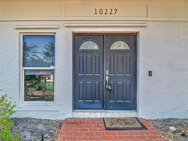view of exterior entry with stucco siding