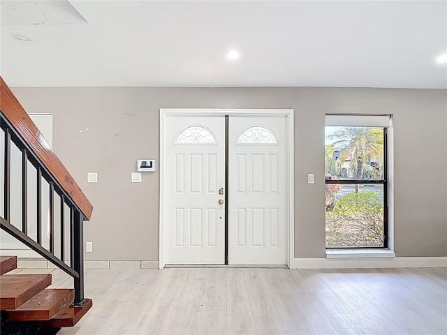 entryway featuring light wood-style flooring, stairs, baseboards, and recessed lighting