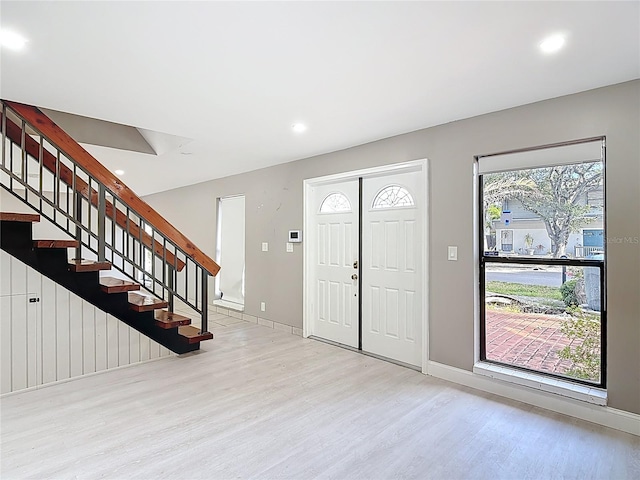 foyer entrance with light wood finished floors, stairs, baseboards, and recessed lighting