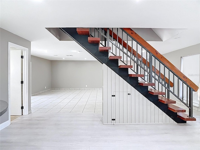 stairway featuring wood finished floors, baseboards, and recessed lighting