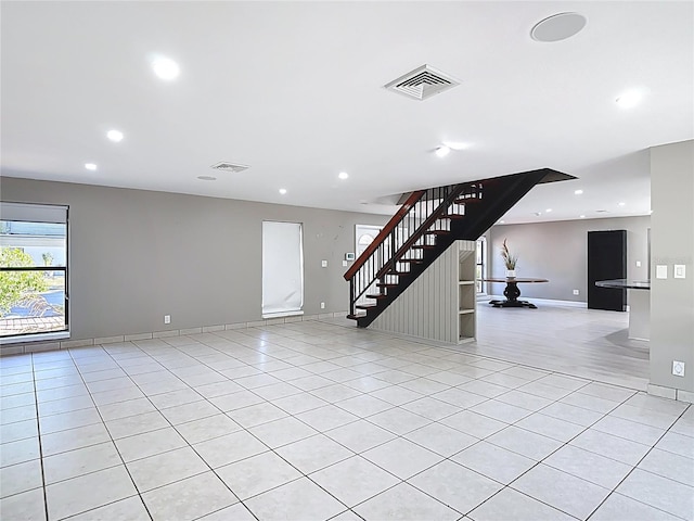 empty room featuring light tile patterned floors, recessed lighting, stairway, and visible vents