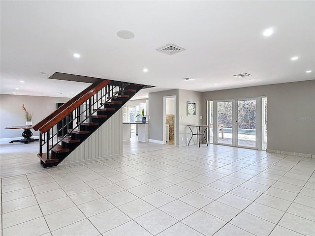 unfurnished living room with french doors, light tile patterned flooring, visible vents, recessed lighting, and stairway