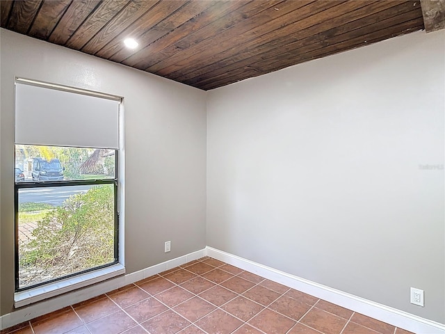spare room with baseboards, dark tile patterned flooring, recessed lighting, and wood ceiling