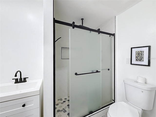 full bath with toilet, vanity, and a stall shower