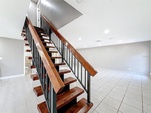 stairway featuring baseboards, visible vents, and wood finished floors