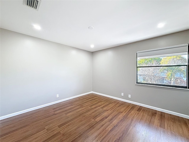 spare room with recessed lighting, baseboards, visible vents, and wood finished floors