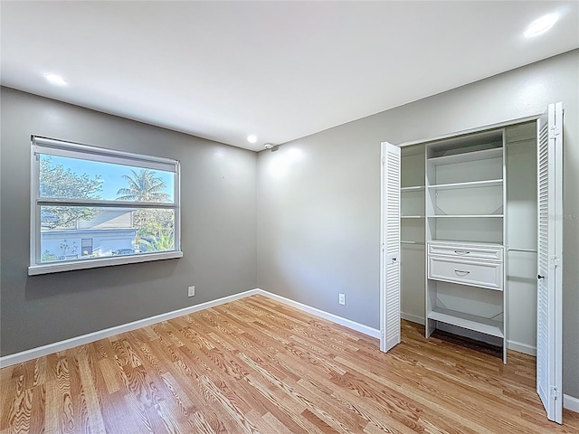 unfurnished bedroom featuring baseboards, recessed lighting, a closet, and light wood-type flooring
