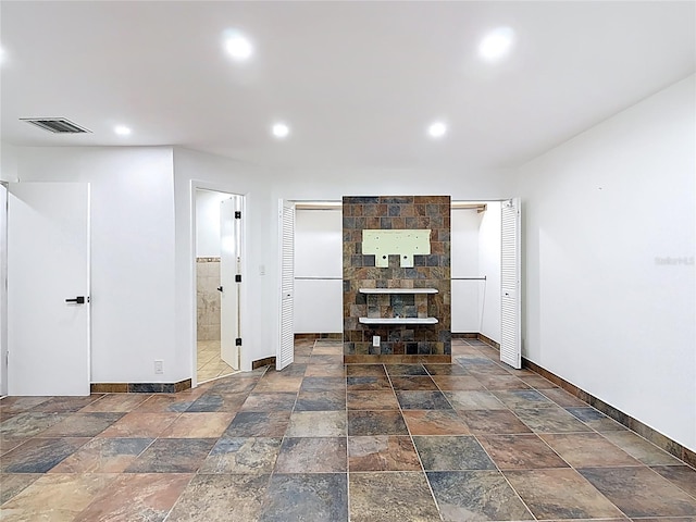 living area featuring baseboards, stone tile floors, and recessed lighting