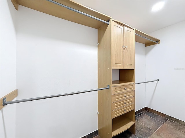 spacious closet with stone tile floors