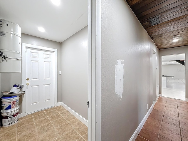 hall with wooden ceiling, baseboards, and light tile patterned floors