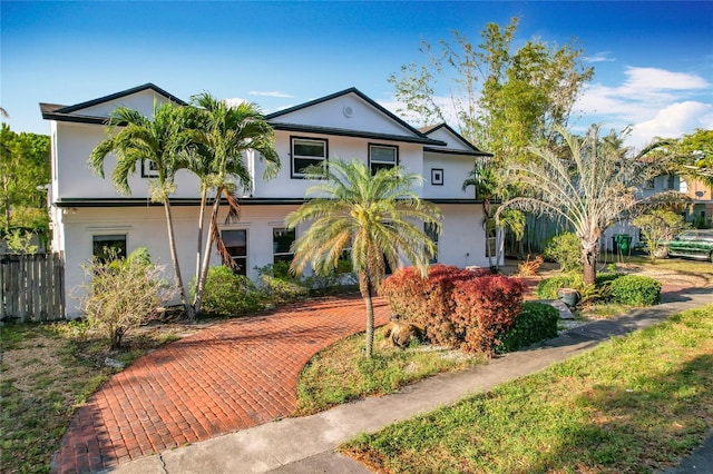 view of front of home featuring stucco siding and fence