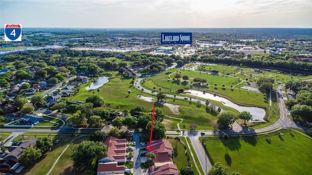 aerial view of property and surrounding area with a large body of water and nearby suburban area