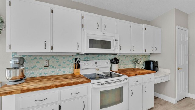 kitchen with white appliances, butcher block countertops, tasteful backsplash, and white cabinets