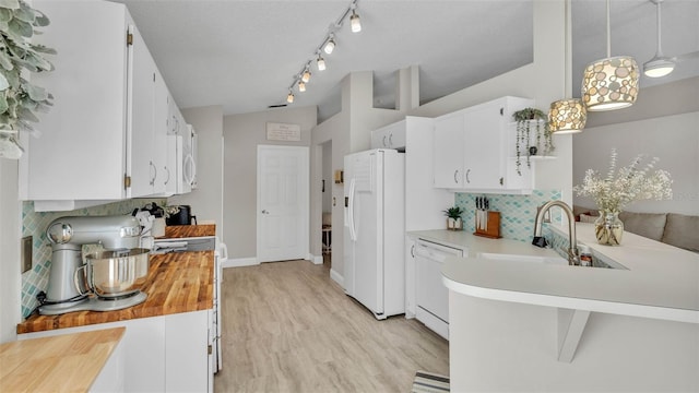 kitchen featuring white appliances, a sink, decorative backsplash, light wood-style flooring, and white cabinets