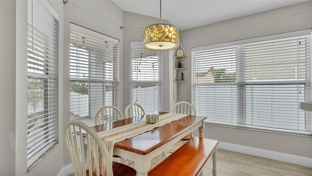 dining room with baseboards, plenty of natural light, and lofted ceiling
